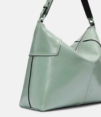 Miętowozielona skórzana torba o luźnym kształcie, z zamknięciem na zamek błyskawiczny oraz kontrastującymi czarnymi akcentami na pasku i brzegach.