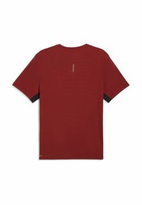 Camiseta roja de manga corta con textura acanalada, hombros curveados, acentos negros contrastantes en las mangas y un pequeño logo en la parte posterior.