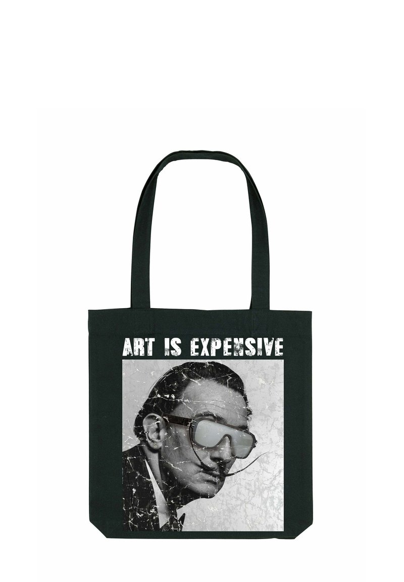 Melnas auduma soma, kurā ir plaisāta printa attēls ar vīrieti brillēs un teksts "MĀKSLAS IR DARGA" treknrakstā baltā krāsā virs tā.