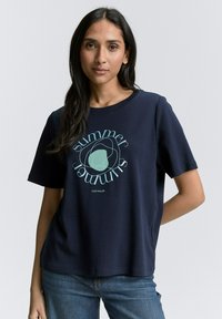 Tamsiai mėlyna medviln�ės marškinėliai su apvalia grafika, kurioje yra žodis "vasara" šviesiai mėlyna. Trumpomis rankovėmis, laisvas kirpimas, apvalus iškirpimas.