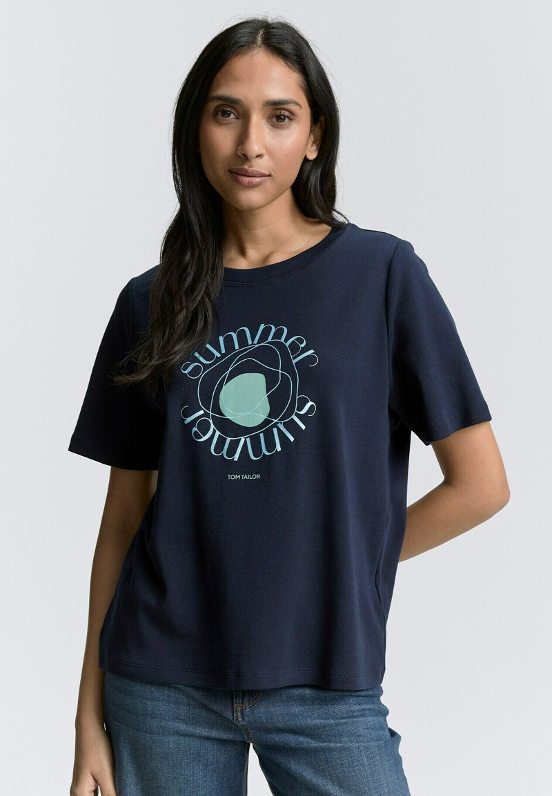 Tamsiai mėlyna medvilnės marškinėliai su apvalia grafika, kurioje yra žodis "vasara" šviesiai mėlyna. Trumpomis rankovėmis, laisvas kirpimas, apvalus iškirpimas.