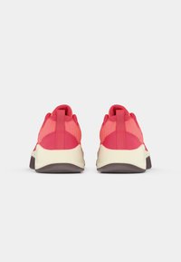 Κόκκινα αθλητικά παπούτσια από διχτυωτό υλικό με ενισχυμένη κρεμ σόλα και υφές. Διαθέτουν θηλιά στο τακούνι για εύκολη εφαρμογή.