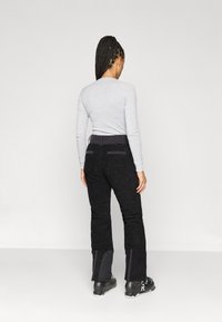 Μαύρο σκι παντελόνι με υφή, με εφαρμοστή σχεδίαση, δύο πίσω τσέπες και αντίθετο υλικό στα κάτω μέρη των ποδιών.