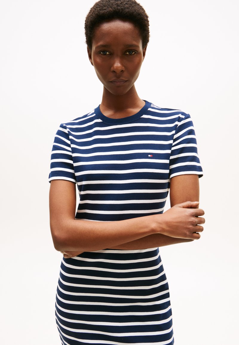 Navy and white striped t-shirt dress, short sleeves, crew neck, ribbed texture, featuring a small logo on the left chest.