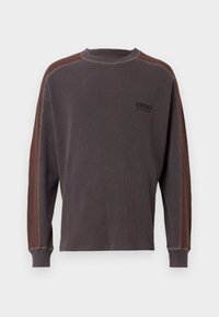 Langærmet sweatshirt i mørkegrå med kontrasterende brune sidepaneler. Struktureret stof, ribbede manchetter og lille logo-detalje på brystet.