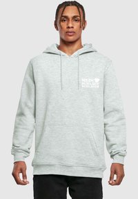 Svetlošedá mikina s klokaními vreckami, so šnúrkou na kapucni a bielym potlačeným textom „MEIN ♥ SCHLAGT SCHLAGER." Mäkký materiál mikiny.