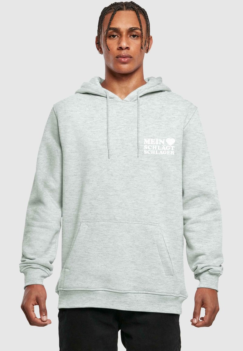Svetlošedá mikina s klokaními vreckami, so šnúrkou na kapucni a bielym potlačeným textom „MEIN ♥ SCHLAGT SCHLAGER." Mäkký materiál mikiny.