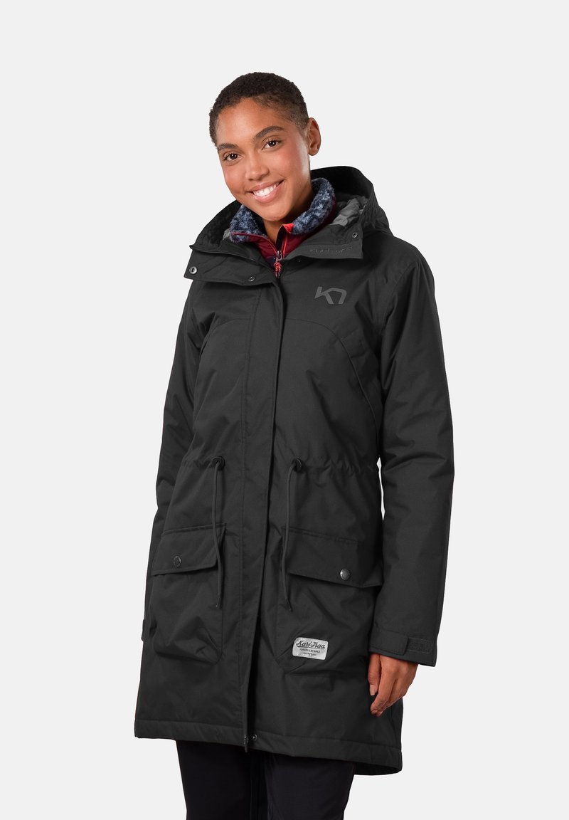 Svart vattentät parka-jacka med huva, med två framfickor, dragsko i midjan och subtil logotyp på bröstet.