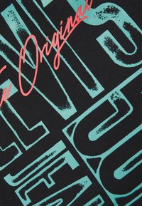 Zwarte stof met levendige turquoise en roze grafische tekst. Bevat vetgedrukte letters met textuuraccenten en een verouderd patroon.