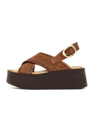 Sandale plateforme en daim marron avec des brides croisées, des détails perforés, une boucle dorée réglable et une semelle épaisse noire.