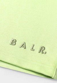 Tela de color verde claro acanalada con el logotipo bordado "B.A.L.R." en un verde apagado. Presenta dobladillo doblado y textura suave.