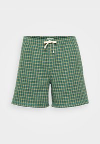 Pantaloni a quadri verdi realizzati in un tessuto testurizzato con vita elasticizzata e cordoncino avorio. Presentano piccoli quadretti di verde scuro e chiaro.