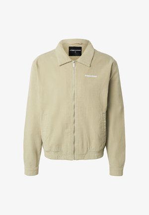 Giacca beige in velluto a coste con cerniera, colletto, orlo elastico, tasche laterali e logo bianco "PEGADOR" sul petto.