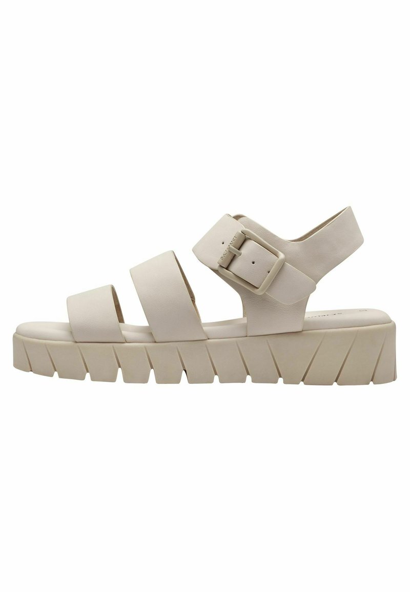 Sandales décontractées beiges avec trois larges brides, boucle ajustable et une semelle épaisse et texturée présentant des rainures diagonales.