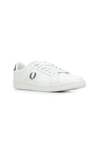 Witte sneaker met groene accenten, met geperforeerde details, ronde neus, vlakke zool en traditionele vetersluiting. Verhoogd logo aan de zijkant.