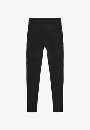 Leggings nere con una fascia elastica larga in vita. Realizzate in un tessuto elastico e liscio, senza motivi o elementi visibili. Vestibilità aderente su tutta la gamba.