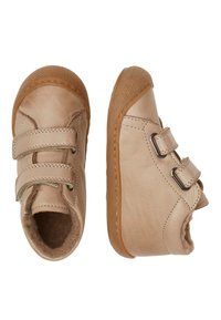 Scarpe in pelle beige con due cinturini in Velcro e fibbia laterale. Punta arrotondata, interno morbido e suola in gomma testurizzata per la presa.