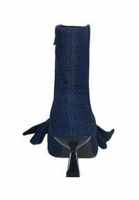 Bottine en tissu bleu marine avec un talon géométrique haut, des nœuds sur les côtés, une surface texturée et un accent lisse en noir sur le talon.