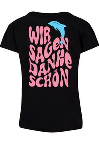 Melnā T-krekla, uz kura ir burbuļu stilā veidots rozā teksts "WIR SAGEN DANKE SCHÖN", un virs tā aizmugurē ir neliels zils delfīns.