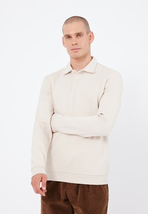 Beige long-sleeve polo shirt with a collared neckline and three-button placket. Made from soft material, features ribbed cuffs and hem.