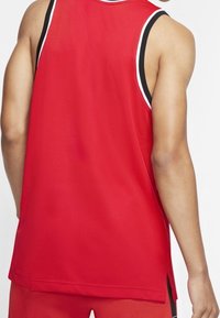 Red athletic tank top with a mesh texture, contrasting black and white trim, side slits, and a relaxed fit shown from the back.