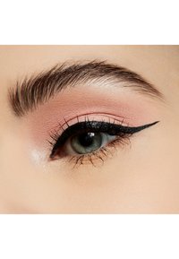 Nærbilde av et øye med myk rosa øyeskygge, definert svart eyeliner som skaper en vinge, og lange vipper. Irisen er grønn med en mørk pupill.