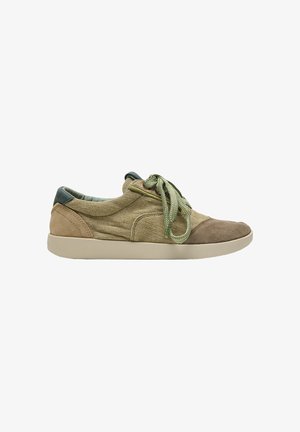Zapatilla casual de perfil bajo con parte superior de tela y ante beige, cordones verdes y suela de goma beige clara, vista desde un lateral sobre fondo blanco.