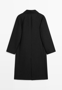 Zwarte wollen jas met een rechte snit, wijde mouwen en een klassieke kraag; voorzien van een split achter voor extra bewegingsvrijheid.