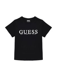 Zwarte katoenen T-shirt met korte mouwen, voorzien van een witte "GUESS Los Angeles" logo in een vet lettertype over de voorkant. Ronde hals, normale pasvorm.