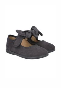 Zapatos de ante negro con punta redondeada, banda elástica y un gran lazo decorativo en el lateral. Suela de goma con un acabado texturizado.