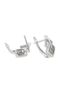 Pár strieborných náušníc s diamantovými akcentmi, jedna je otvorená a zobrazuje mechanizmus zapínania, na bielom pozadí.