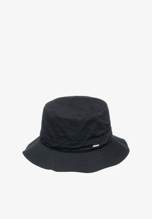 Black bucket hat made of textured fabric with a wide brim. Features a small white logo tag on the side and a smooth, rounded crown.