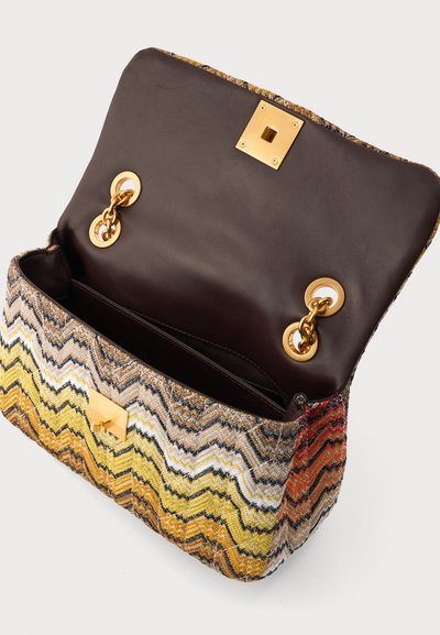 Sac à main avec motif zigzag multicolore, rabat en cuir marron foncé ouvert, et attaches et fermoir en chaîne dorée.