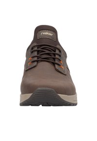 Zapato marrón con cordones y textura suave, acentos naranjas en contraste, suela de goma y un collar acolchado. Presenta una marca en la lengüeta.