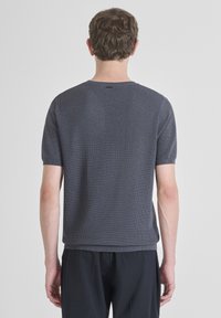 Majica s kratkim rukavima, rebrasta, u tamnosivoj tkanini. Ima okrugli izrez i ravni kroj. Jednostavna pozadina bez vidljivih logotipa ili uzoraka.