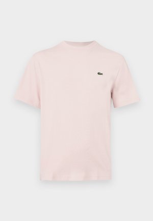 Plain light pink short-sleeve t-shirt with a small green crocodile logo on the left chest, displayed against a white background.