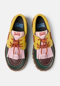 Colorful leather shoes featuring a yellow, pink, green, and brown design, with fringe accents and brown rubber soles. Brand markings visible.