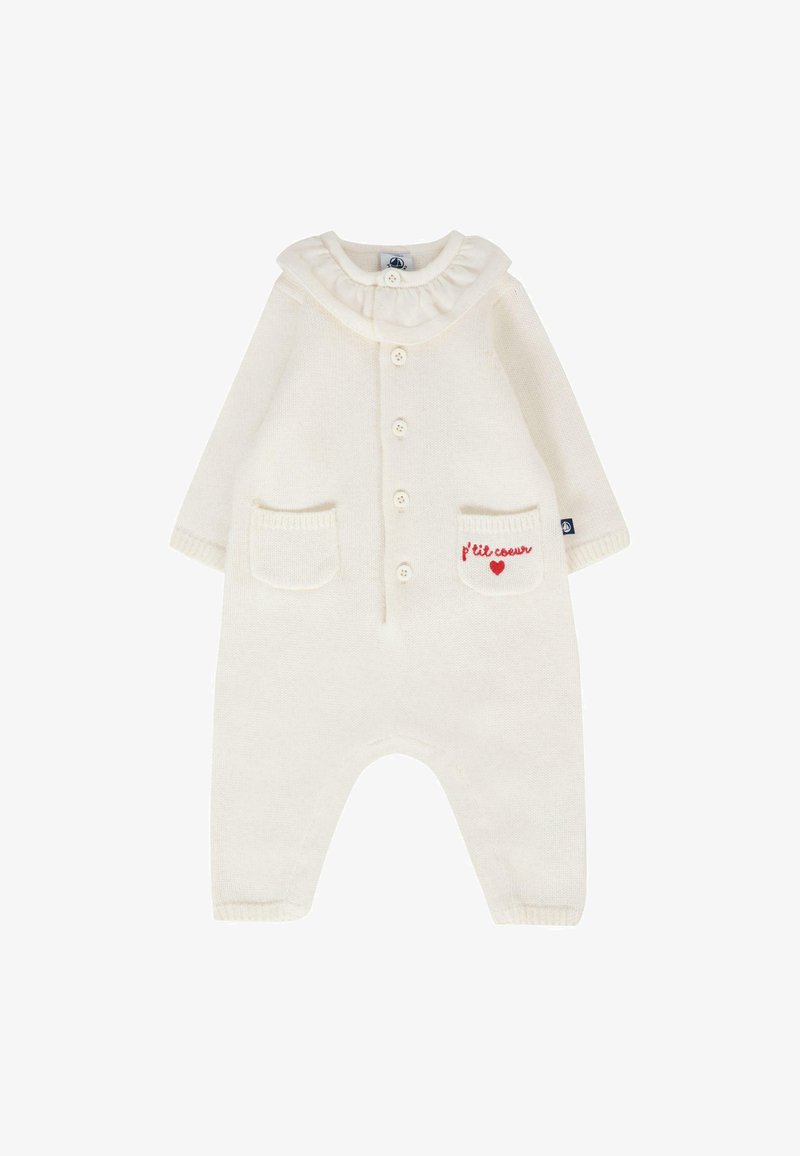 Grenouillère pour bébé en tricot blanc avec un col volé, des boutons sur le devant, deux poches et une broderie rouge sur une des poches.
