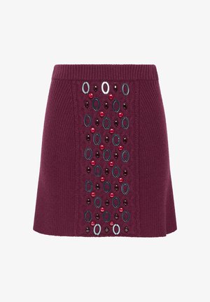 Gonna a maglia color bordeaux con fascia in vita a coste. Presenta decorazioni ovali e circolari in vari colori sul davanti.