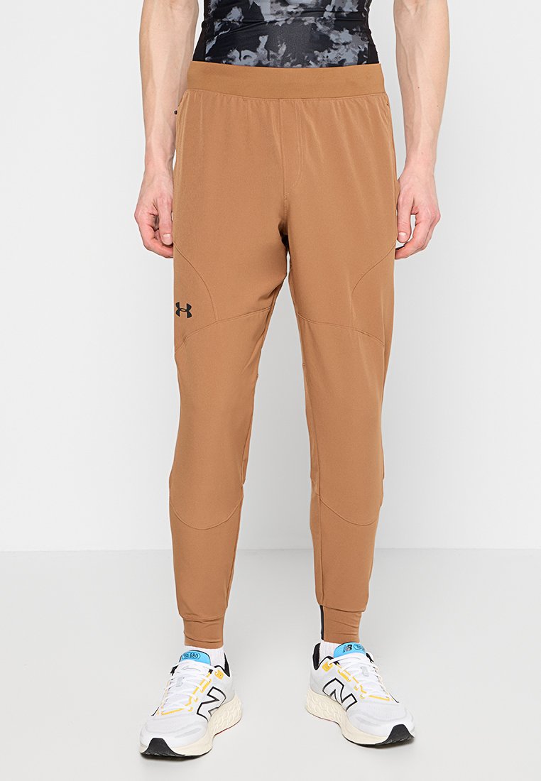 Pantalones de chándal marrones hechos de tejido ligero, con un corte tapered, cinturilla elástica y acento de logo negro.