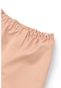 Svetlo rožnata tkanina z gladko teksturo, ki ima elastičen pas z naborki in gumbnim okrasjem.