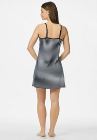 Svītrains kleita ar plānām siksnām, kurai ir tumši zilas un baltas horizontālas svītras, izteikta apakšdaļa un garums līdz vidum augšstilbam. Gluda auduma struktūra.