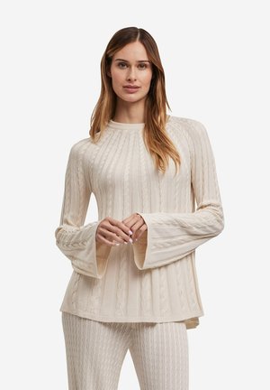 Ivory ribbed sweater with long bell sleeves, featuring cable-knit patterns and a round neckline, paired with matching knit bottoms.