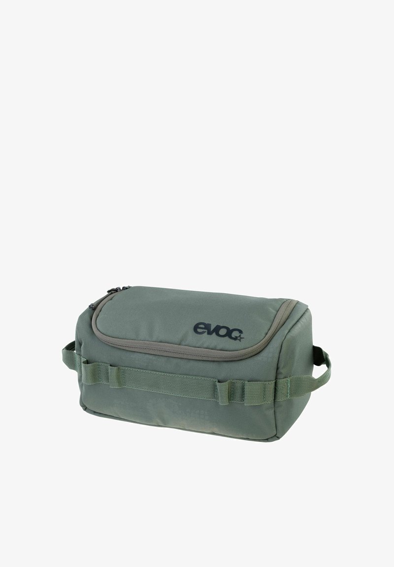Green fabric storage bag with a zip closure, featuring a smooth texture, reinforced edges, and a logo detail. Adjustable side straps present.