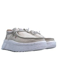 Zapatos de lino beige con un acabado texturizado, que presentan una suela gruesa blanca con motas y un diseño con cordones. Los acentos añaden un detalle sutil.