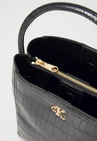 Borsa a tracolla nera in pelle sintetica effetto coccodrillo con forma strutturata, zip dorata e logo in evidenza. L'interno presenta una tasca con zip e foderatura in tessuto.