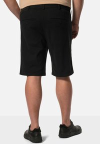 Pantalones cortos negros de mezcla de algodón, hasta la rodilla, que cuentan con dos bolsillos traseros con cierres de botón y una textura suave y mate.
