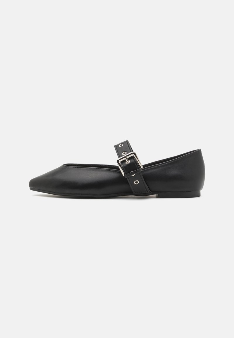 Chaussure plate en cuir noir avec un bout pointu, une bande latérale dotée d'une boucle en argent et un petit talon. Texture lisse et design minimaliste.