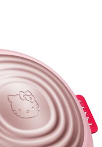 Rosa silikon skål med ribbad insida och präglat Hello Kitty-ansikte, med ett rött handtag med text. Slät yta och rund form.