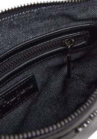 Portafoglio nero con zip, dotato di un interno in tessuto testurizzato e un'etichetta in pelle liscia. Presenta più scomparti per una migliore organizzazione.